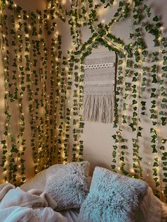 a bed covered in lots of green plants next to a wall with lights on it