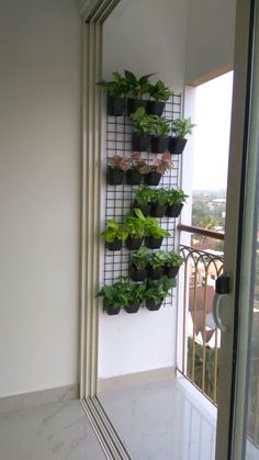 a wall mounted planter on the side of a building with plants growing in it