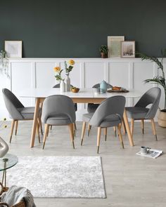 a dining room table with grey chairs around it