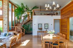 a living room and dining area in a house with wood flooring, stairs leading to the second floor