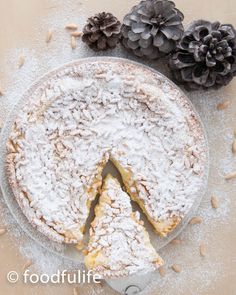 a cake with powdered sugar on top and pine cones next to it, sitting on a plate