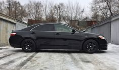 a black car is parked in the snow