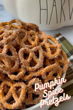 a bowl full of pumpkin spice pretzels sitting on top of a plaid table cloth