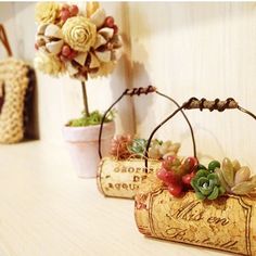 three wine corks with flowers in them sitting on a shelf next to a purse