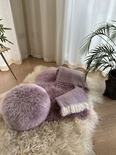 a furry rug on the floor next to a potted plant