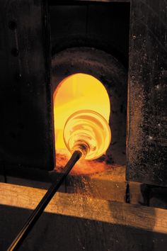 a close up of a piece of metal with a light in the background and a torch sticking out of it