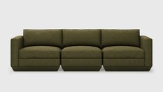 a green couch with three reclinings on the back and one arm facing forward