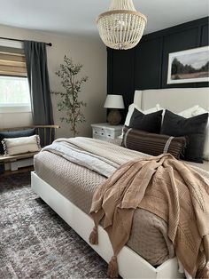 a bedroom with a large bed and a chandelier hanging from the ceiling