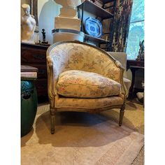 a chair sitting on top of a rug next to a table with vases and other items