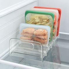 three plastic containers filled with food sitting on top of an open refrigerator