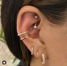 a woman's ear with three different types of piercings on her left side