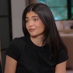 a woman with long black hair sitting down