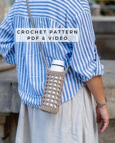 a woman wearing a blue and white striped shirt holding a crochet purse over her shoulder