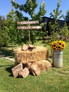 a hay bale with sunflowers and a sign