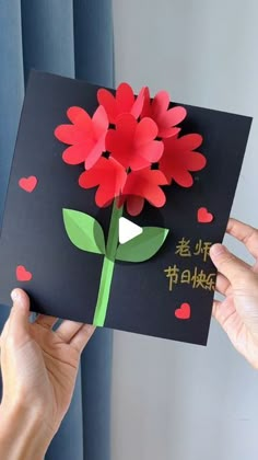 someone is holding up a card with flowers on it