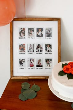 a white cake sitting on top of a wooden table next to an orange rose and some balloons