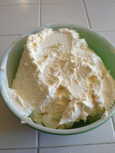 a bowl filled with whipped cream on top of a white tiled floor