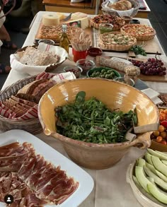 a table filled with lots of different types of food on top of plates and bowls