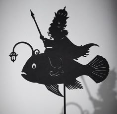 a black silhouette of a fish on top of a pole