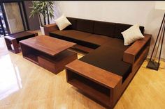 a living room filled with furniture on top of a hard wood floor covered in white pillows