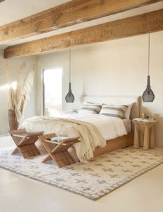 a bedroom with white walls and wooden beams