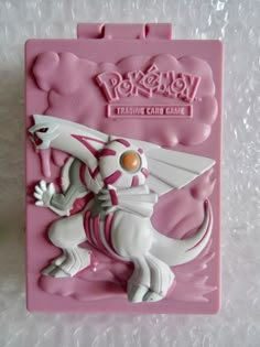 a pokemon trading card game with a white and pink dragon on it's back