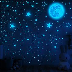 stars and moon glow in the dark blue night sky, with a stuffed animal sitting on the floor