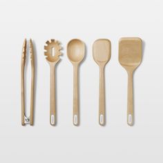 wooden utensils and spoons lined up on a white surface