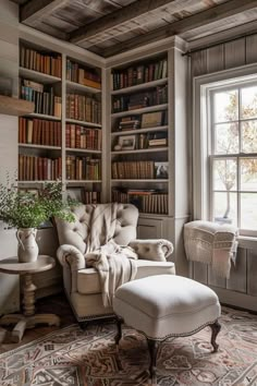 a chair and ottoman in front of a window with bookshelves on either side