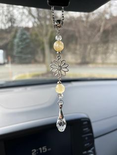 a car dashboard with a flower hanging from it's dash board and some beads