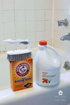 a bottle of baking soda sitting on top of a bath tub next to a brush