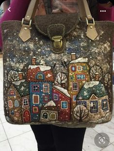 a woman holding a handbag with houses painted on it's front and sides