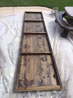 a wooden plank laying on top of a tarp