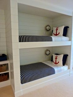 there are two bunk beds in the room with white walls and black and white bedding