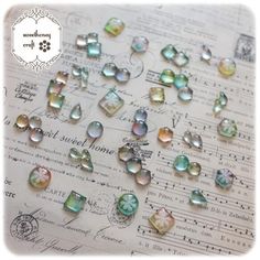 many different colored glass beads on top of music sheet