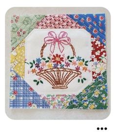 an image of a basket with flowers in it on a patchwork piece of cloth