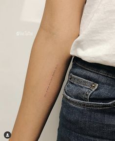 a woman's arm with a small tattoo on the left side of her arm