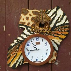 a clock that is on the side of a wooden wall with an animal print design