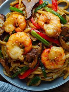 a plate with noodles, shrimp and mushrooms on it that says shanghai noodle stir fry