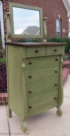 a green painted dresser with a mirror on top