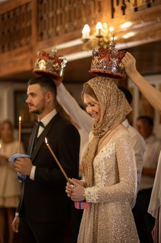 a woman wearing a crown and holding a wand in her hand while standing next to a man