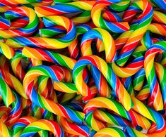 many colorful candy canes are stacked together