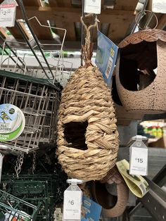 several birdhouses hanging from the ceiling in a store with price tags on them and other items for sale