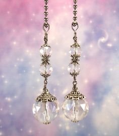 the earrings are hanging from the chain on the earwires, and have clear crystal beads