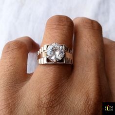 a person's hand with a ring on it and a diamond in the middle