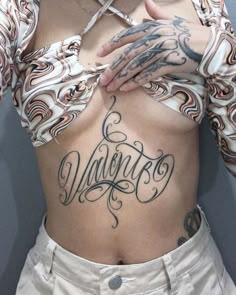 a woman with tattoos on her stomach has the word vancouver written in cursive writing