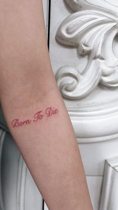 a woman's arm with the word born to die tattooed on her left arm