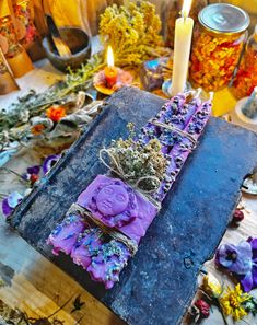 a table topped with lots of different types of flowers next to candles and other items