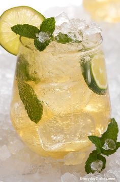 a glass filled with lemonade and lime on top of ice