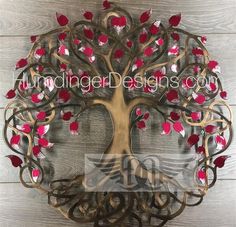 a metal tree with red leaves on it and the words autumn design is displayed in front of a wooden wall